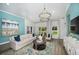 Bright living room with blue accent wall, stylish furniture, and large windows overlooking the yard at 1022 Brimstone Cir, Winter Haven, FL 33884