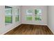 Bright bedroom featuring hardwood floors, base molding, and multiple windows with view at 1616 Ellesmere Ave, Haines City, FL 33844