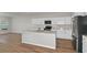 Modern kitchen featuring white cabinets, stainless steel appliances, island, and hardwood floors at 1616 Ellesmere Ave, Haines City, FL 33844