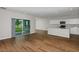 Open-concept living room features wood floors, sliding glass doors, and a modern kitchen with a breakfast bar at 1616 Ellesmere Ave, Haines City, FL 33844