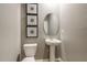 Modern powder room with a pedestal sink, toilet, and decorative wall art at 2004 Marigold Aly, Winter Haven, FL 33884
