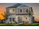 Charming two-story home featuring a covered front porch and manicured lawn at sunset at 2004 Marigold Aly, Winter Haven, FL 33884