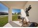 Cozy patio area with wicker furniture and decorative wall art overlooking the front yard at 2004 Marigold Aly, Winter Haven, FL 33884