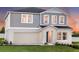 Two-story home featuring a gray exterior, attached two-car garage, and well-maintained front lawn at 2212 Canyon Oak Dr, Davenport, FL 33837