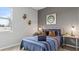 Stylish bedroom featuring a striped blue quilt, wood side tables with decorative items, and a window at 3317 Armstrong Ave, Clermont, FL 34714