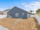 Blue home exterior with a sliding glass door, white fence and a grassy yard at 438 Cotswold Cir, Davenport, FL 33837