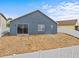 Blue home exterior with a sliding glass door, white fence and a grassy yard at 438 Cotswold Cir, Davenport, FL 33837
