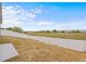 Sloping backyard featuring a white fence with a view of some commercial buildings at 438 Cotswold Cir, Davenport, FL 33837