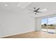 Spacious room with a modern ceiling fan, a sliding glass door that leads to a balcony and wood flooring at 438 Cotswold Cir, Davenport, FL 33837