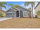 Inviting single-story home with a gray exterior, lush landscaping and a two-car garage at 438 Cotswold Cir, Davenport, FL 33837