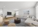 Cozy living room with hardwood flooring, a large sofa and a modern entertainment center at 438 Cotswold Cir, Davenport, FL 33837