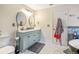 This bathroom features double sinks, a modern vanity, and tiled floors at 16755 Sunrise Vista Dr, Clermont, FL 34714