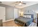 Comfortable bedroom featuring a fan, two bedside lamps, and hard wood floors at 16755 Sunrise Vista Dr, Clermont, FL 34714