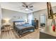 Comfortable bedroom featuring a fan, two bedside lamps, and hard wood floors at 16755 Sunrise Vista Dr, Clermont, FL 34714