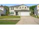 Two story home with a two car garage, neutral colored paint, and well manicured lawn at 16755 Sunrise Vista Dr, Clermont, FL 34714