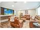 Living room area with couches, wood floors, large TV, and built in shelving at 16755 Sunrise Vista Dr, Clermont, FL 34714