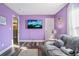 Cozy living room featuring lilac walls, modern gray flooring, and a comfortable couch at 16755 Sunrise Vista Dr, Clermont, FL 34714