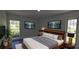 Modern bedroom with a wooden headboard, decorative lighting, and two TVs at 25322 Columbia Cir, Lake Wales, FL 33898