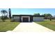 Charming single-story home with a well-manicured lawn and a long driveway leading to an attached garage at 25322 Columbia Cir, Lake Wales, FL 33898