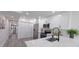 Modern white kitchen with stainless steel appliances, an island sink, and gray wood flooring at 25322 Columbia Cir, Lake Wales, FL 33898