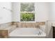 Main bathroom features a large soaking tub and a window with natural light at 2846 Sera Bella Way, Kissimmee, FL 34744