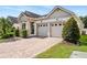 Inviting home with a brick driveway, two-car garage, and manicured landscaping at 2846 Sera Bella Way, Kissimmee, FL 34744