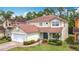 Charming two-story home with a red tile roof, two car garage and well-manicured landscaping at 320 Mockingbird Rd, Davenport, FL 33896