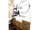 Bathroom with a farmhouse sink, modern fixtures, ladder shelving and a round mirror at 1464 Mount Pleasant Rd, Groveland, FL 34736