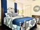 Bedroom featuring an iron bed frame, blue and white patterned bedding, and cozy decor at 1464 Mount Pleasant Rd, Groveland, FL 34736