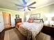 Well-lit primary bedroom features a ceiling fan, wood dresser, and decorative lamps and decor at 1464 Mount Pleasant Rd, Groveland, FL 34736