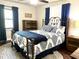 Comfortable bedroom with a wrought iron bed frame, blue accent pillows, and a coordinating area rug at 1464 Mount Pleasant Rd, Groveland, FL 34736