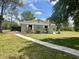 Lovely home with manicured landscaping, a stone walkway, and a screened in patio at 1464 Mount Pleasant Rd, Groveland, FL 34736
