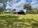 A beautifully maintained home with a metal roof, a screened in porch, and a large lawn at 1464 Mount Pleasant Rd, Groveland, FL 34736