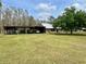 Home exterior showing carport, lush green lawn, and mature trees on a sunny day at 1464 Mount Pleasant Rd, Groveland, FL 34736