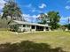 Inviting single-story home with mature landscaping, a covered porch, and a well-manicured lawn at 1464 Mount Pleasant Rd, Groveland, FL 34736
