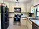 Well-lit kitchen featuring stainless steel appliances, tile floors, and modern cabinetry at 1464 Mount Pleasant Rd, Groveland, FL 34736