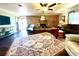 Inviting living room with a brick fireplace, ceiling fan, hardwood floors, and a large area rug, perfect for relaxation at 1464 Mount Pleasant Rd, Groveland, FL 34736