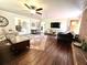 Spacious living room features an area rug, hardwood floors, and brick fireplace at 1464 Mount Pleasant Rd, Groveland, FL 34736