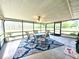 Enclosed sun room with tile floor, ceiling fan and a glass view of nature and a table for outdoor dining at 1464 Mount Pleasant Rd, Groveland, FL 34736