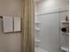A well-lit bathroom showcases a white shower with built-in shelving and neutral patterned shower curtain at 3856 King Hill Dr, Haines City, FL 33844