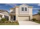 Charming two-story home with neutral siding, a blue front door, and an attached two-car garage at 4075 Gardenia Ave, Lake Hamilton, FL 33851