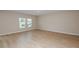 Bright, empty, living room with LVP flooring and two windows at 4075 Gardenia Ave, Lake Hamilton, FL 33851
