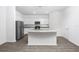 Modern kitchen featuring white cabinets, granite countertops, stainless steel appliances, and wood-style flooring at 13280 Tula Loop, Astatula, FL 34705