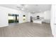 Bright open-plan living space with wood-style flooring, white walls, ceiling fan, and sliding glass doors at 13280 Tula Loop, Astatula, FL 34705