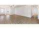 Bright living room with wood-look floors, fresh white walls, and an open doorway at 1794 White Elephant Loop, Winter Haven, FL 33884