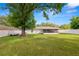 Expansive backyard with lush green grass, a white fence, and a screened-in patio at 2937 Delrose N Dr, Lakeland, FL 33805