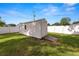 Backyard storage shed with a ramp and a white fence, providing secure storage space at 2937 Delrose N Dr, Lakeland, FL 33805