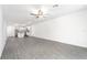 Open-concept living space adjacent to the kitchen, featuring a ceiling fan and wood floors at 3183 Seville St, Lake Alfred, FL 33850