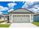 Two car garage with carriage doors and gray and white exterior paint at 3736 Bergamot St, Lake Alfred, FL 33850