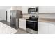 Modern kitchen featuring granite countertops, stainless steel appliances, and ample cabinet space at 3736 Bergamot St, Lake Alfred, FL 33850